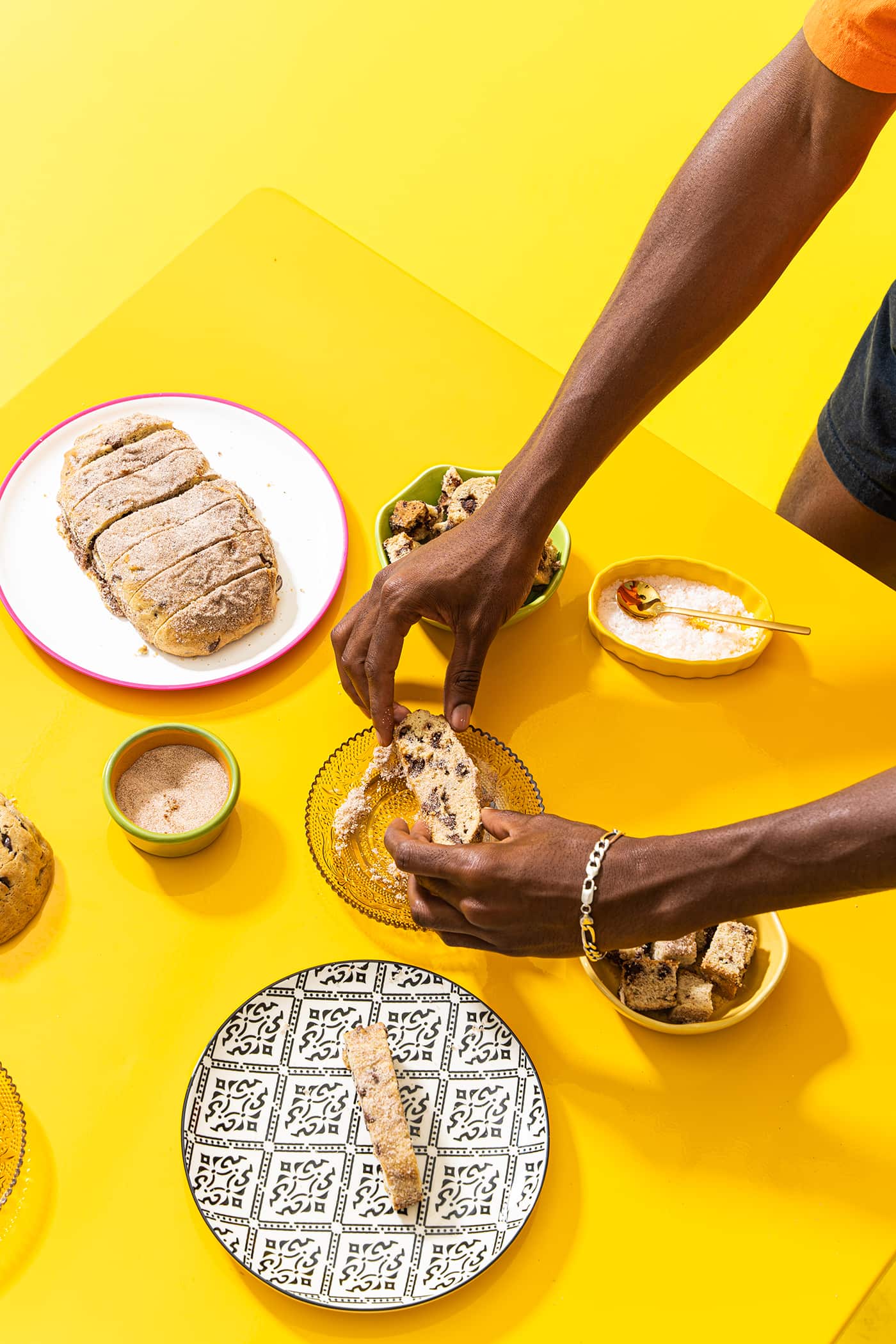 Man's hands breaking a slice of Wandel bread over a set table