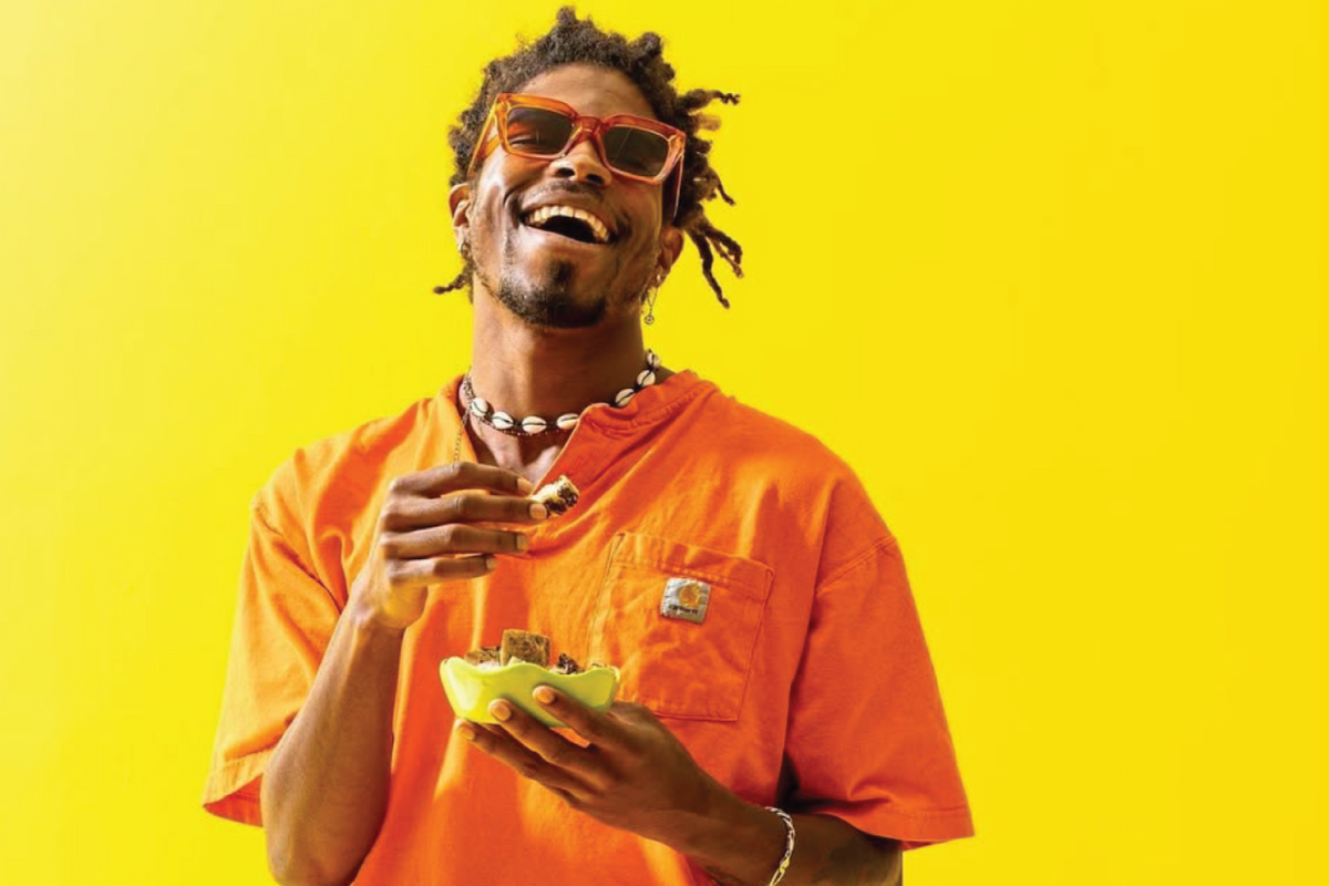 A bright, colorful gentleman smiles in sunglasses while enjoying Wandel bites.